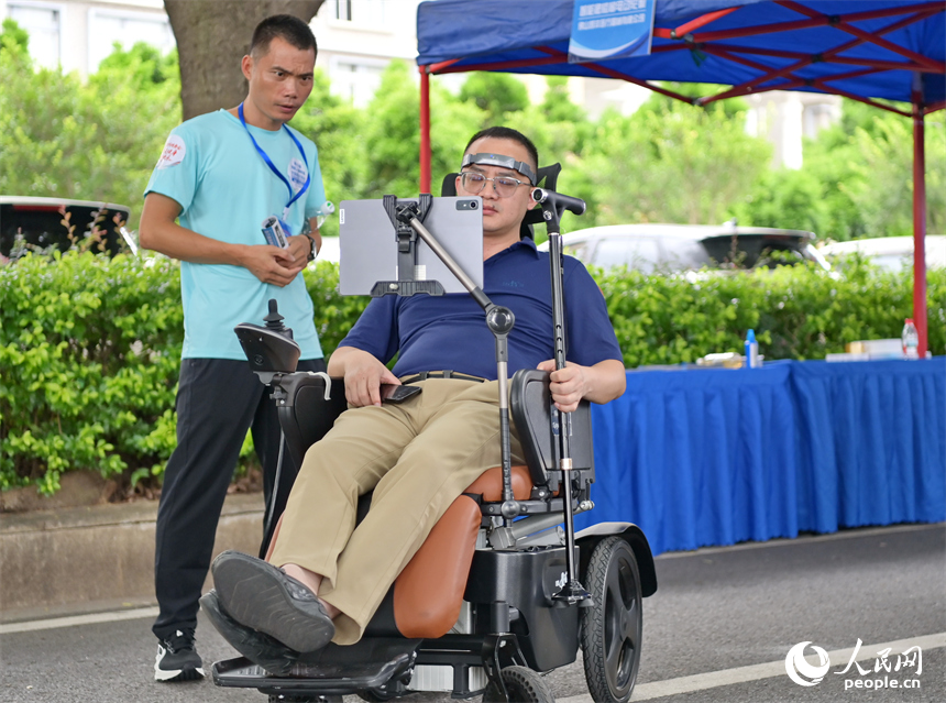 參觀者在科技助殘展區咨詢試用人工智能康復輔助器具產品。人民網 朱海鵬攝