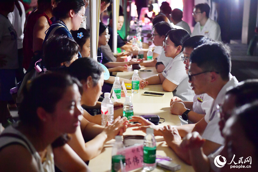 “中医夜市”上，中医师为市民和游客提供免费诊疗和健康咨询。人民网记者 时雨摄