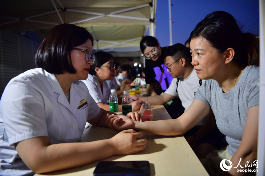 “中医夜市”上，中医师为市民把脉问诊。人民网记者 时雨摄