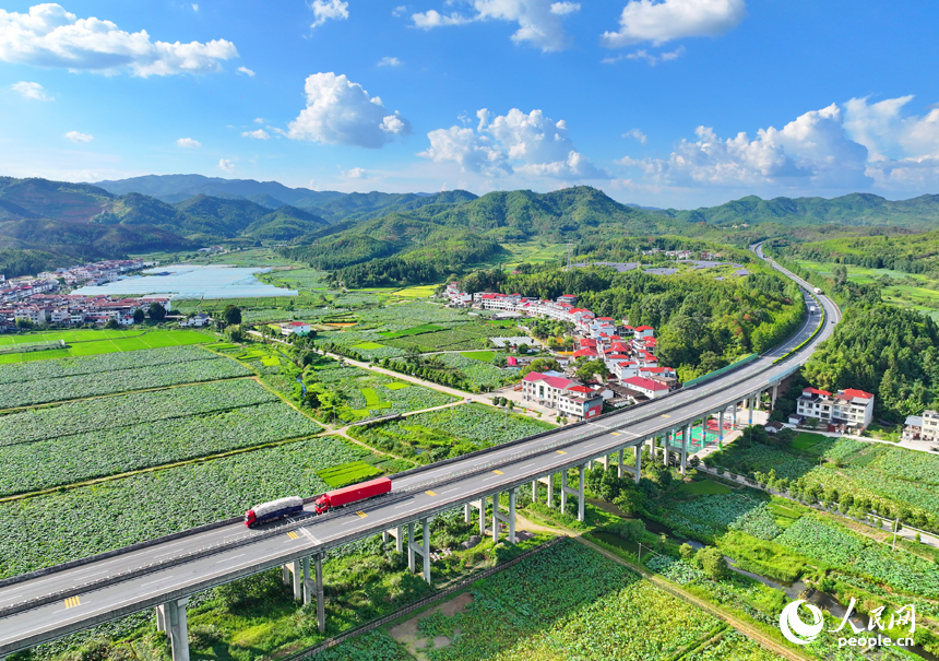 贛州市石城縣小鬆鎮許坊村，濟廣高速車輛穿行於層巒疊嶂的青山之間，初秋鄉村美景怡人。人民網 朱海鵬攝