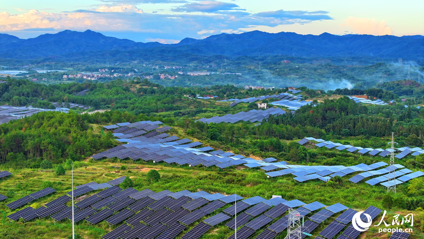 抚州市南丰县莱溪乡西山村“农光互补”光伏发电站，荒山坡上安装的光伏板熠熠生辉，与绿树青山相映相衬。人民网 朱海鹏摄