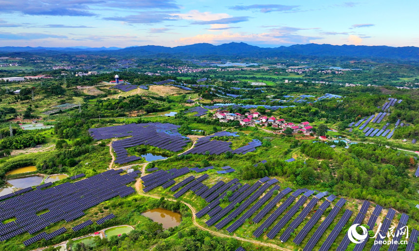 抚州市南丰县莱溪乡西山村“农光互补”光伏发电站，荒山坡上安装的光伏板熠熠生辉，与绿树青山相映相衬。人民网 朱海鹏摄