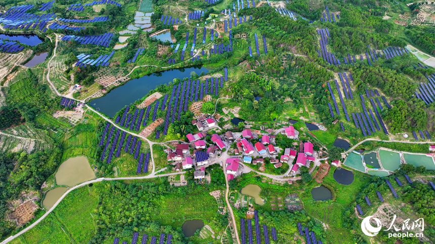 抚州市南丰县莱溪乡西山村“农光互补”光伏发电站，荒山坡上安装的光伏板熠熠生辉，与绿树青山相映相衬。人民网 朱海鹏摄