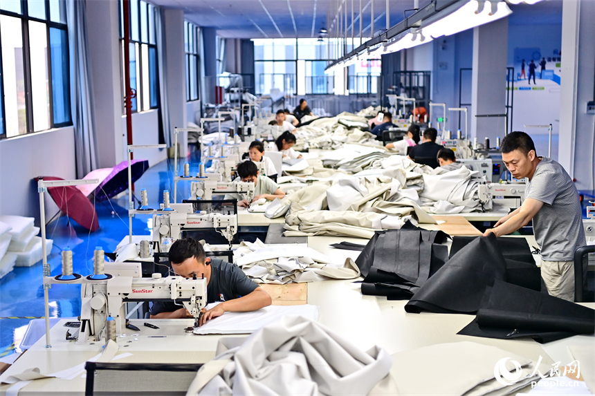 贛州市南康區的一家“工業上樓”項目家具生產企業內，工人在加工軟體家具。人民網 朱海鵬攝