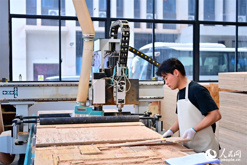 贛州市南康區的一家“工業上樓”項目家具生產企業內，工人在加工軟體家具。人民網 朱海鵬攝