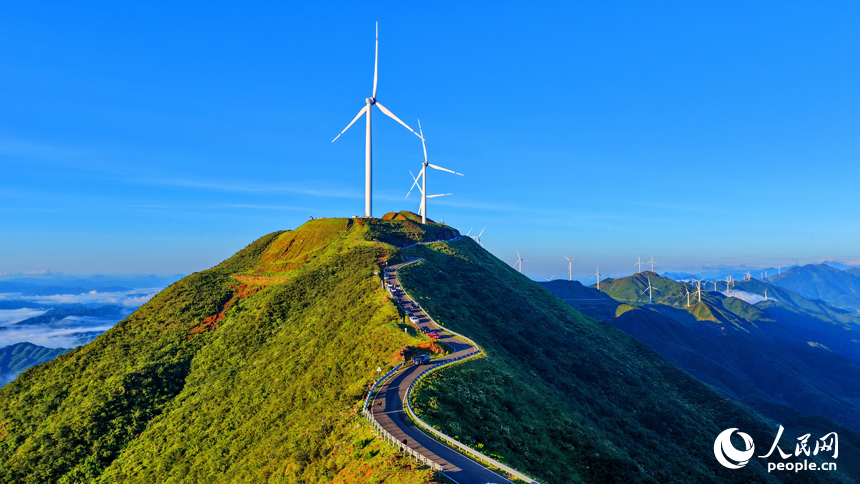 贛州市上猶縣的雙溪草山筑峰頂，新能源風力發電機組與連綿青山相映成景，吸引游客前來觀光打卡。人民網 朱海鵬攝