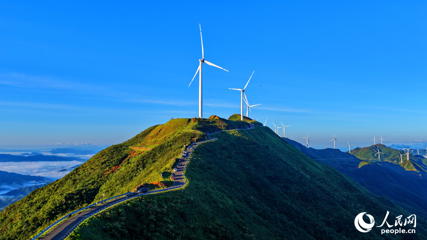 贛州市上猶縣的雙溪草山筑峰頂，新能源風力發電機組與連綿青山相映成景，吸引游客前來觀光打卡。人民網 朱海鵬攝