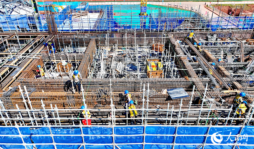 信丰电厂二期项目建设现场塔吊林立，施工作业有序，工人在吊装锅炉钢结构设备。人民网 朱海鹏摄