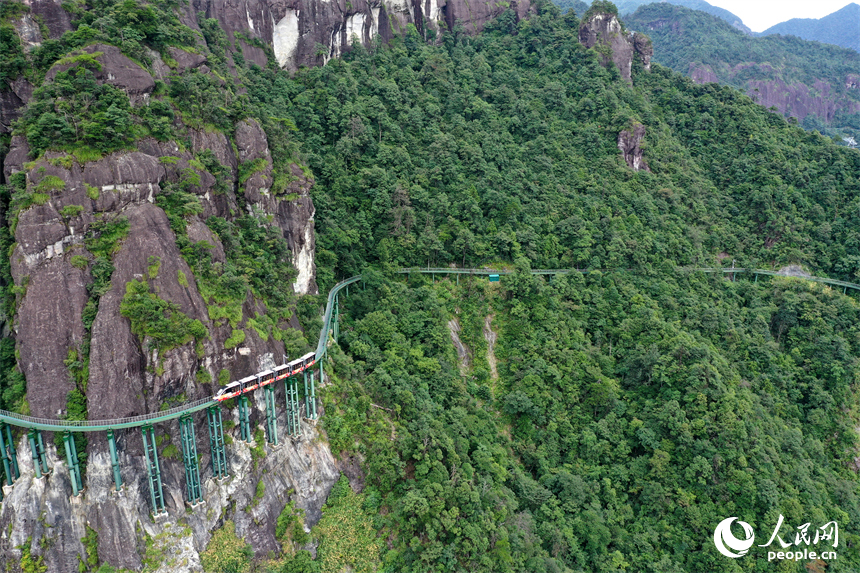 資溪縣大覺山景區，懸崖動車在綠山間穿行，游客們感受“雲端飛馳”的刺激與震撼。人民網記者 時雨攝
