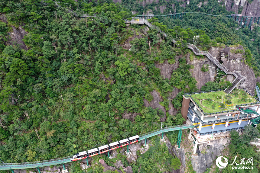 资溪县大觉山景区，悬崖动车在绿山间穿行，游客们感受“云端飞驰”的刺激与震撼。人民网记者 时雨摄