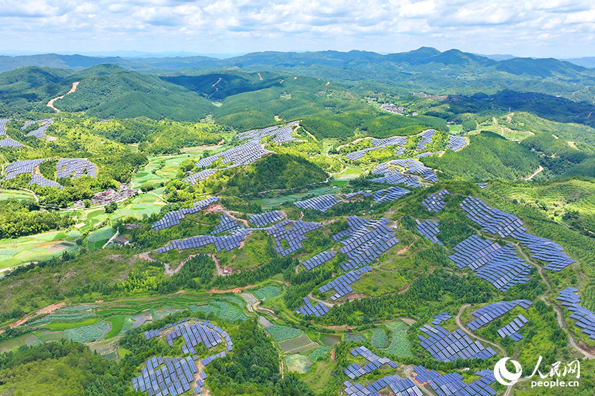贛州市石城縣琴江鎮的一處光伏發電基地，鱗次櫛比的太陽能光伏板與青山綠樹、村庄田園相映襯，大地如同披上藍色“外衣”。人民網 朱海鵬攝