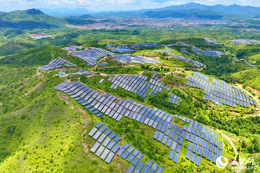 贛州市石城縣琴江鎮的一處光伏發電基地，鱗次櫛比的太陽能光伏板與青山綠樹、村庄田園相映襯，大地如同披上藍色“外衣”。人民網 朱海鵬攝