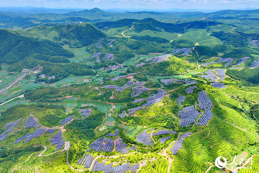 贛州市石城縣琴江鎮的一處光伏發電基地，鱗次櫛比的太陽能光伏板與青山綠樹、村庄田園相映襯，大地如同披上藍色“外衣”。人民網 朱海鵬攝