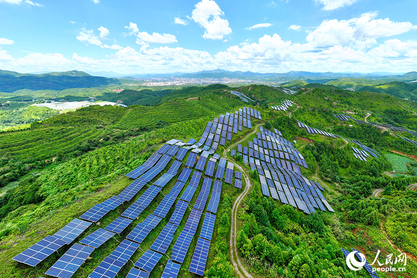 贛州市石城縣琴江鎮的一處光伏發電基地，鱗次櫛比的太陽能光伏板與青山綠樹、村庄田園相映襯，大地如同披上藍色“外衣”。人民網 朱海鵬攝