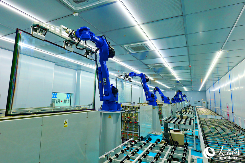 安遠縣產城新區的一家光電科技有限公司智能化生產車間內，一排排機器人揮舞著機械臂加緊作業。人民網 朱海鵬攝