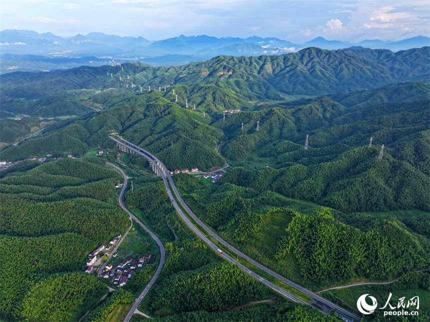 抚州市资溪县嵩市镇，抚（州）至吉（安）高速公路如同银龙蜿蜒穿梭于苍翠的崇山峻岭间，与田园、村落相映成景。人民网 朱海鹏摄