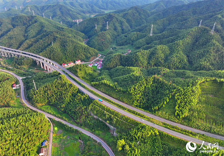 抚州市资溪县嵩市镇，抚（州）至吉（安）高速公路如同银龙蜿蜒穿梭于苍翠的崇山峻岭间，与田园、村落相映成景。人民网 朱海鹏摄
