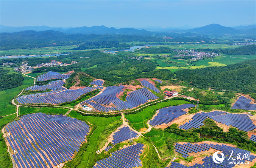 德興市香屯街道蘭村村20MW集中式光伏電站，荒山坡上的一排排光伏發電板熠熠生輝，源源不斷地輸出綠色電能。人民網 朱海鵬攝