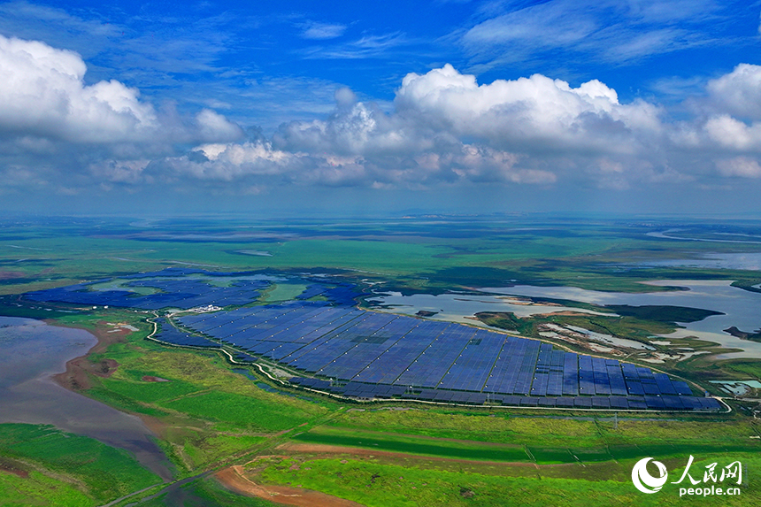 共青城市江益镇帅家村，连片的蓝色光伏发电板整齐排列、蔚为壮观，与农田、湖泊等构成一幅色彩斑斓的田园画卷。人民网 朱海鹏摄
