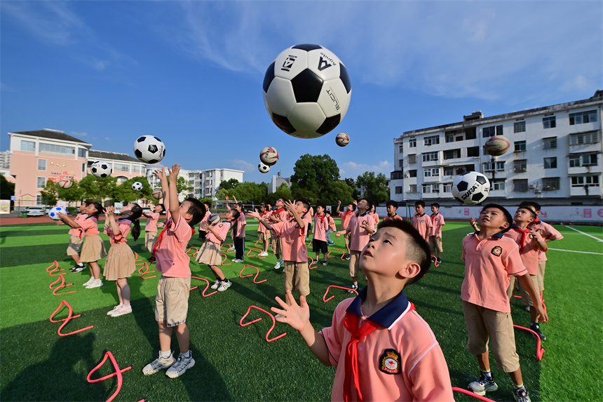 操场上，学生们在参加足球活动。邓龙华摄