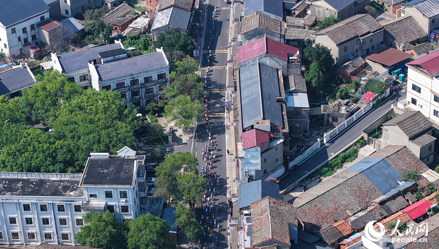 第十三屆環鄱陽湖國際自行車大賽永修站16日在永修縣吳城鎮啟航，圖為選手們在賽道競速。人民網記者 時雨攝