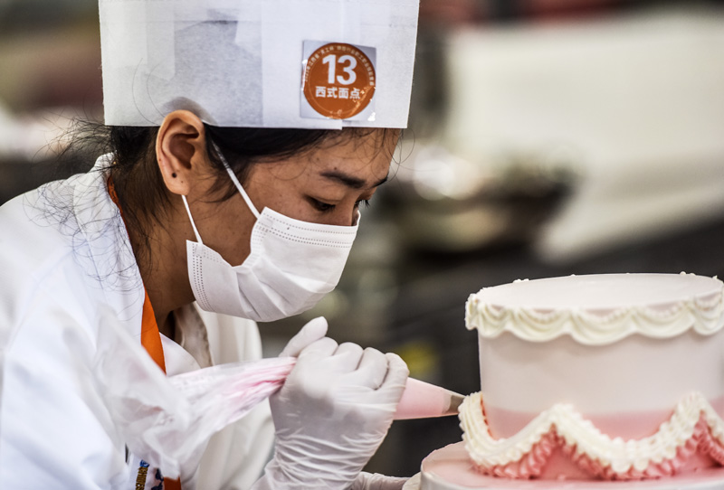 參賽選手在江西省撫州市資溪縣中等專業學校無菌教室內制作蛋糕。
