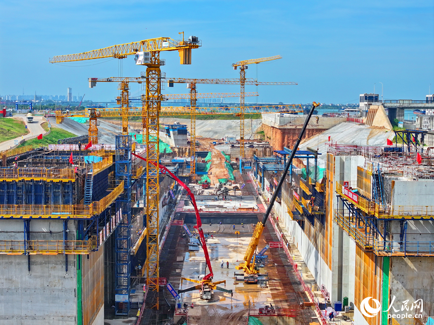 赣江龙头山枢纽二线船闸工程建设现场塔吊林立，施工繁忙，工人在浇筑船闸主体结构。人民网 朱海鹏摄