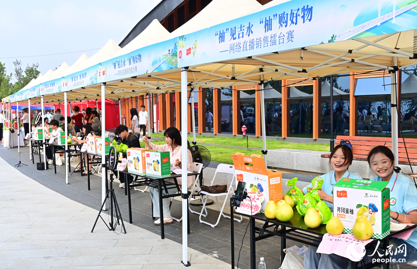 活动现场，参加网络直播销售擂台赛的主播们通过直播助力井冈蜜柚销售。人民网 朱海鹏摄