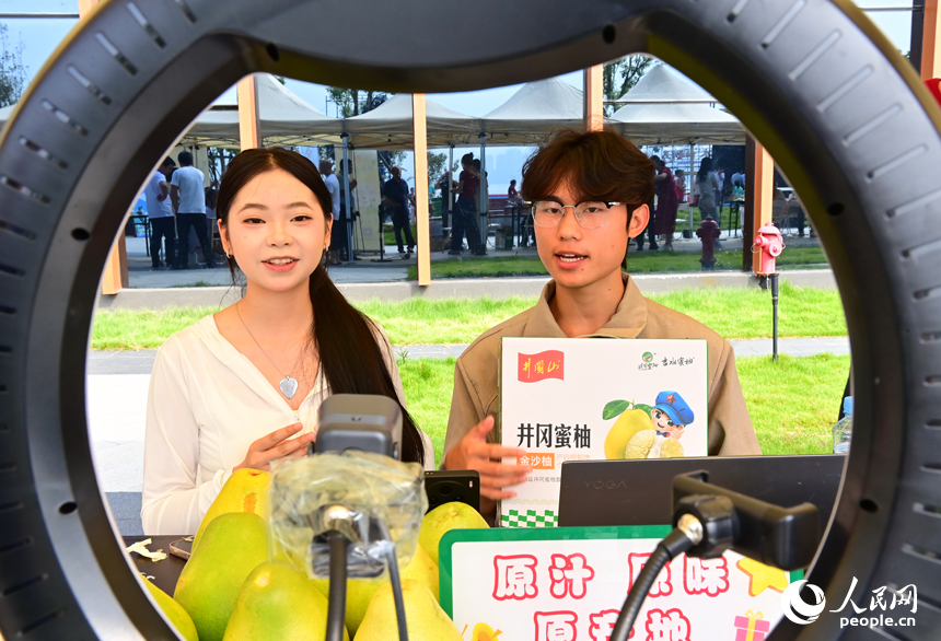 活动现场，参加网络直播销售擂台赛的主播们通过直播助力井冈蜜柚销售。人民网 朱海鹏摄