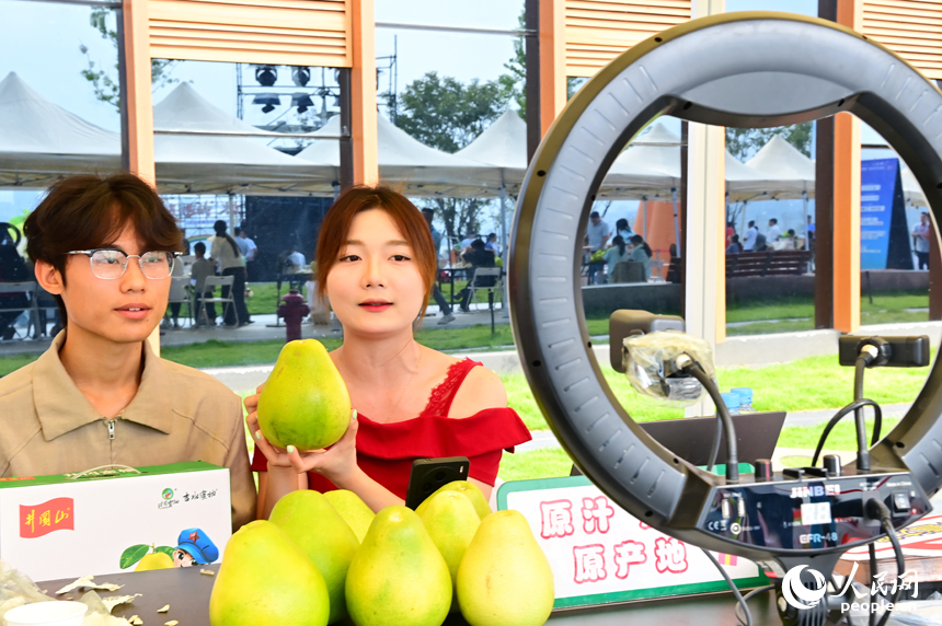 活动现场，参加网络直播销售擂台赛的主播们通过直播助力井冈蜜柚销售。人民网 朱海鹏摄