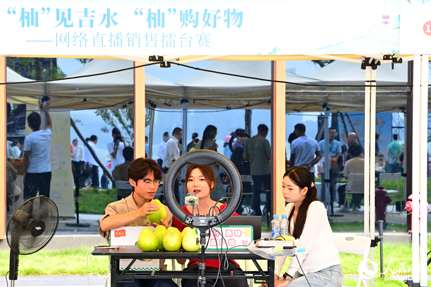 活动现场，参加网络直播销售擂台赛的主播们通过直播助力井冈蜜柚销售。人民网 朱海鹏摄