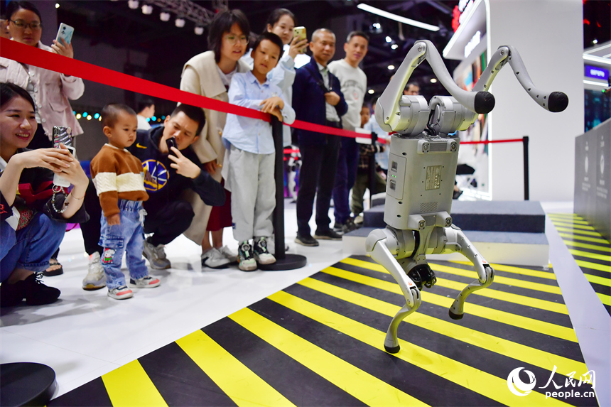 正在跳舞的机器狗吸引群众围观。人民网记者 时雨摄
