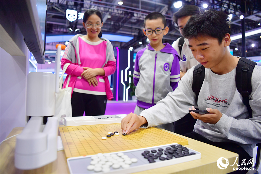 游客与机器人下棋吸引人们驻足观看。人民网记者 时雨摄