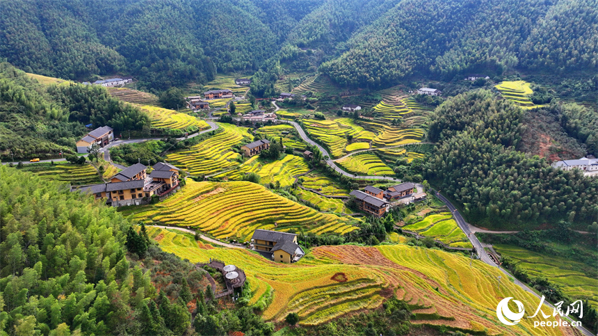 赣州市崇义县上堡乡，层层叠叠的梯田沿山体绵亘蜿蜒，与错落分布的农家房屋、旅游民宿相映成画。人民网 朱海鹏摄
