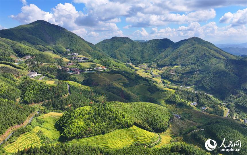 赣州市崇义县上堡乡，层层叠叠的梯田沿山体绵亘蜿蜒，与错落分布的农家房屋、旅游民宿相映成画。人民网 朱海鹏摄