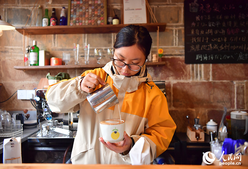 返村創業的青年正在老舊民宅改造的開咖啡館內制作咖啡。人民網記者 時雨攝