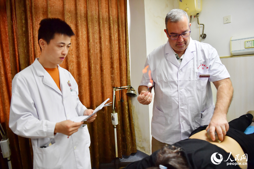 “洋中醫”正在進行拔火罐治療的考核。人民網記者 時雨攝
