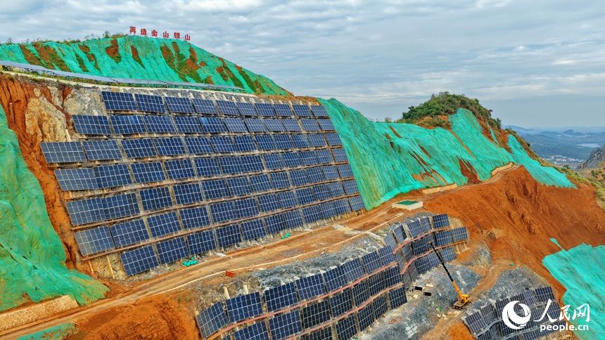 新余仙女湖区欧里镇昌坊村金石山，矿山修复工人在给山体立面安装光伏发电板。人民网记者 朱海鹏摄