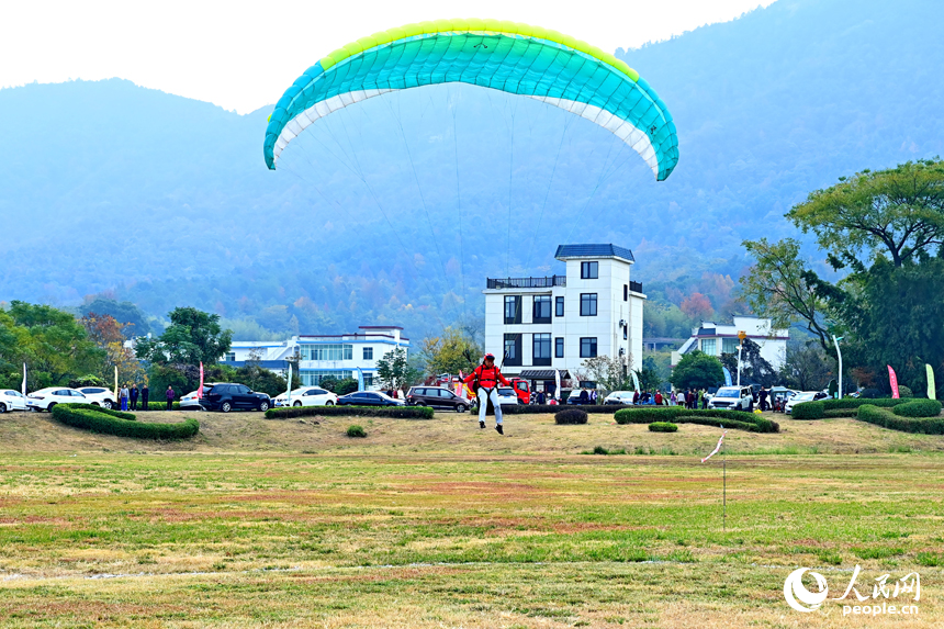 南康區龍回鎮布谷寨航空飛行營地，動力傘編隊、滑翔傘表演和比賽吸引眾多游客前來觀看。人民網記者 朱海鵬攝