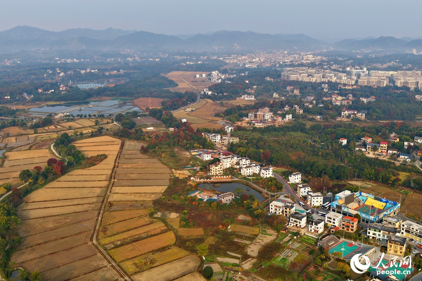 南康區龍回鎮龍東村，綿延山巒與房屋、農田、樹木相互映襯，構成一幅色彩繽紛的冬日鄉村畫卷，吸引眾多游客前來游玩。人民網記者 朱海鵬攝
