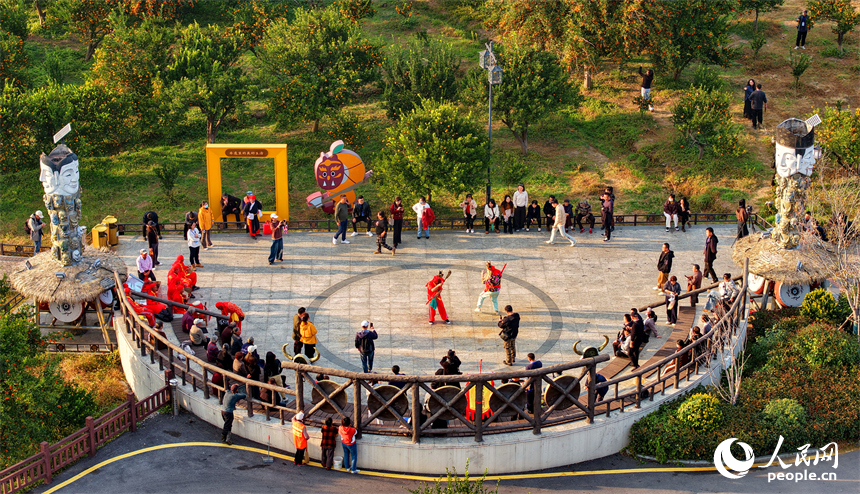撫州市南豐縣琴城鎮水南村貢橘苑，村民和游客在觀看南豐儺舞表演。人民網記者 朱海鵬攝