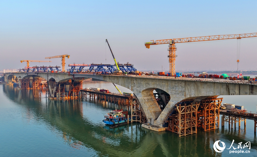 南昌市昌南大橋項目施工現場，吊裝設備來回作業，最后兩段中跨鋼箱梁成功合龍，收尾施工有序進行。人民網記者 朱海鵬攝