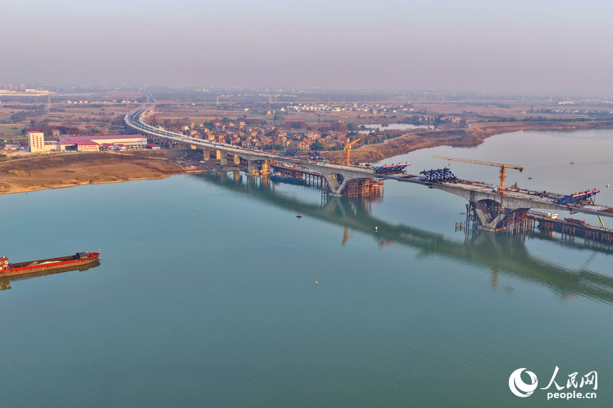 南昌市昌南大橋項目施工現場，吊裝設備來回作業，最后兩段中跨鋼箱梁成功合龍，收尾施工有序進行。人民網記者 朱海鵬攝