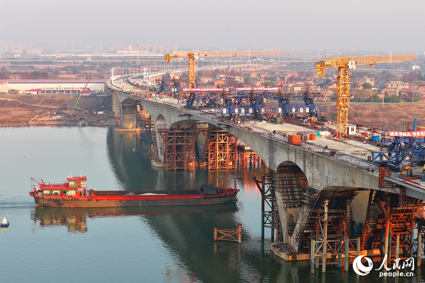 南昌市昌南大橋項目施工現場，吊裝設備來回作業，最后兩段中跨鋼箱梁成功合龍，收尾施工有序進行。人民網記者 朱海鵬攝