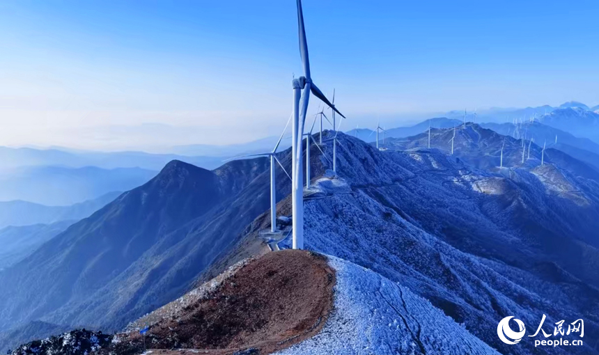 赣州市上犹县双溪乡草上的风力发电场，一台台风力发电机矗立在山巅，与蓝天白云、蜿蜒群山、皑皑白雪相映成景，构成一幅冬日高山冰雪美景。人民网记者 朱海鹏摄