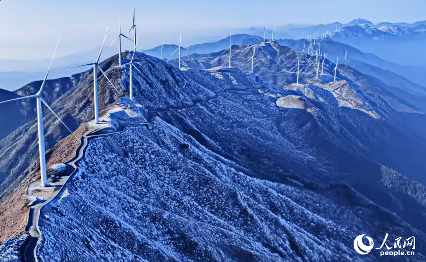 赣州市上犹县双溪乡草上的风力发电场，一台台风力发电机矗立在山巅，与蓝天白云、蜿蜒群山、皑皑白雪相映成景，构成一幅冬日高山冰雪美景。人民网记者 朱海鹏摄