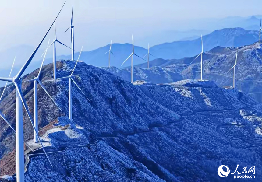赣州市上犹县双溪乡草上的风力发电场，一台台风力发电机矗立在山巅，与蓝天白云、蜿蜒群山、皑皑白雪相映成景，构成一幅冬日高山冰雪美景。人民网记者 朱海鹏摄