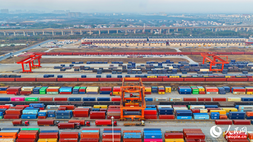 南昌国际陆港货运场站内，货物集装箱装卸有序进行，运输车辆往来穿行。人民网记者 朱海鹏摄