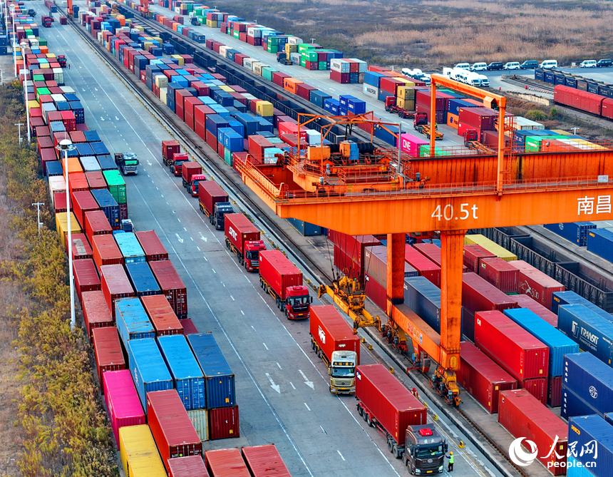 南昌国际陆港货运场站内，货物集装箱装卸有序进行，运输车辆往来穿行。人民网记者 朱海鹏摄