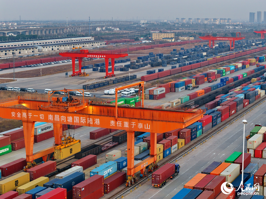 南昌国际陆港货运场站内，货物集装箱装卸有序进行，运输车辆往来穿行。人民网记者 朱海鹏摄